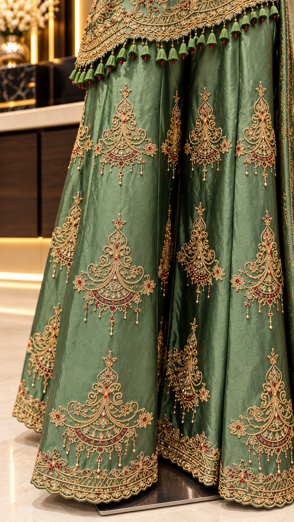 Sage green palazzo pants with embroidered motifs and scalloped border