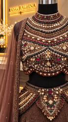 Close-up of kundan, pearl and stone embellished high-neck blouse on brown lehenga